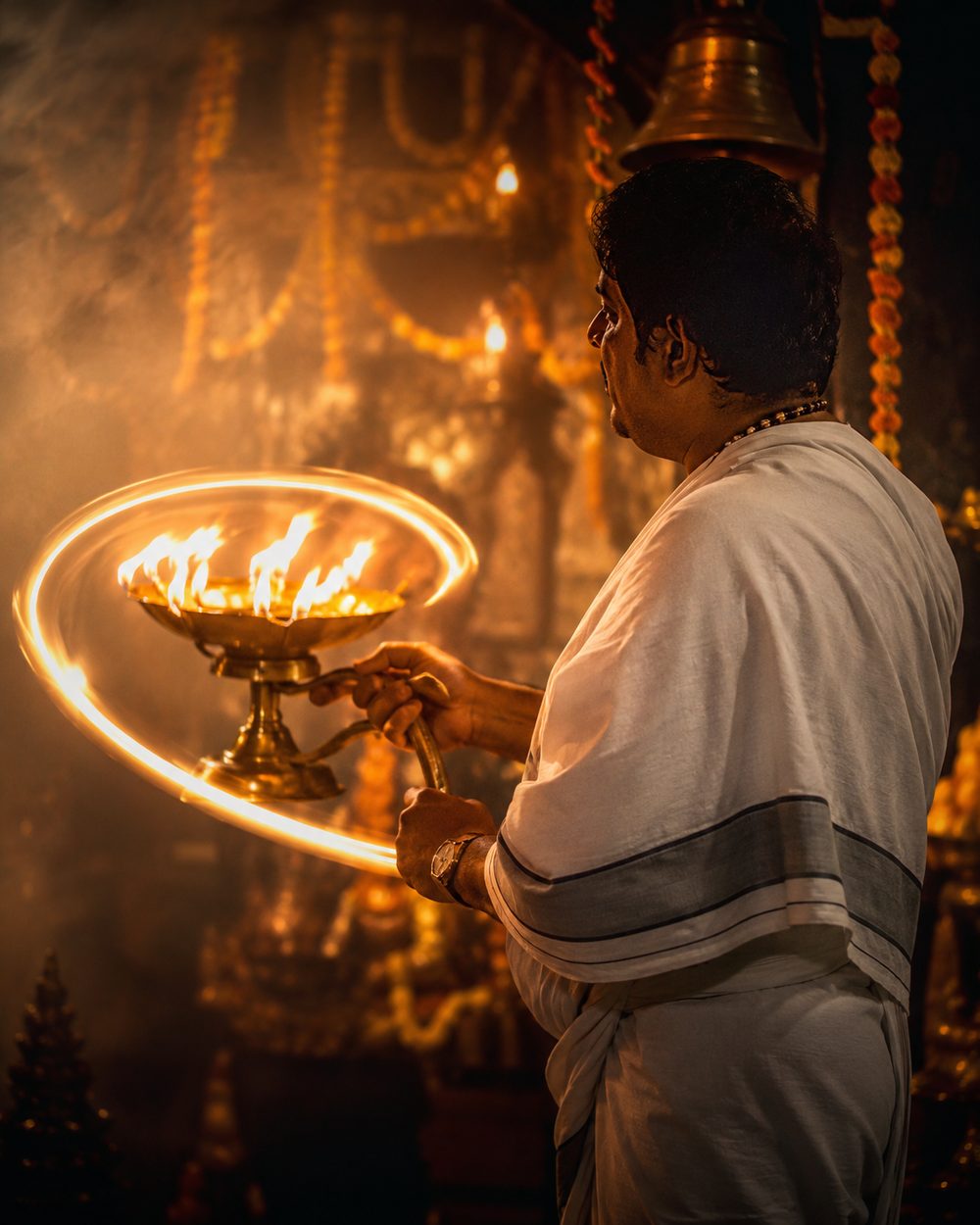 Priest performing aarti during a deity installation ceremony